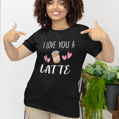 T-shirt preta com texto e ilustração de café, usada por mulher sorridente em ambiente interior com plantas
