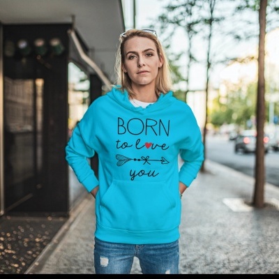 Pessoa vestindo sweatshirt azul turquesa com estampa 'BORN to love you' num cenário urbano