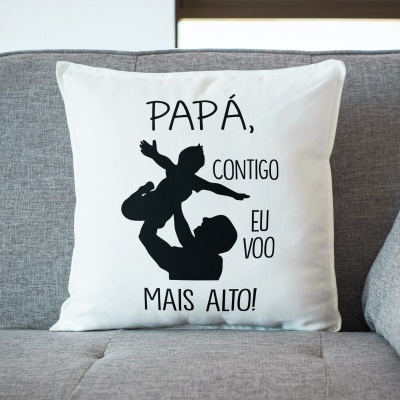 Almofada branca com texto e imagem preta num sofá cinzento.