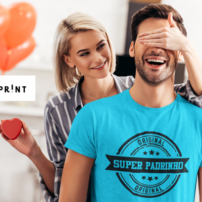 Casal com homem vestindo camiseta azul com texto e mulher segurando caixa em forma de coração