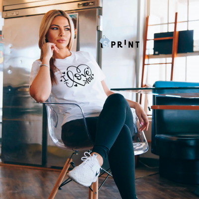 Camisola branca com impressão 'I love you' usada por mulher sentada numa cadeira transparente