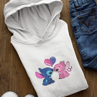 Sweatshirt branca com capuz e estampa colorida de personagens, ao lado calças de ganga e sapatos brancos.