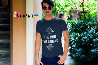 Homem com t-shirt azul escura com texto branco em ambiente exterior com plantas