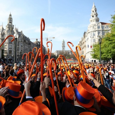 Grupo de pessoas com chapéus e bengalas laranjas em evento ao ar livre