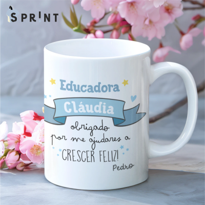 Caneca branca com texto em várias cores e flores cor-de-rosa ao fundo