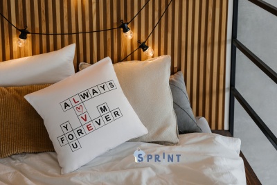 Almofadas em cama com almofada branca decorativa com palavras e corações vermelhos