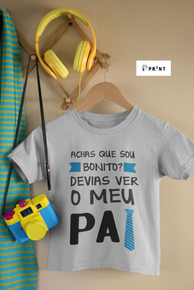 Camisola cinza de criança com texto em português, auscultadores amarelos, casaco às riscas azuis e verdes e câmara de brincar azul e amarela