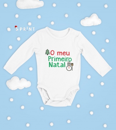 Body branco de manga comprida para bebé com texto 'O meu Primeiro Natal' e desenhos natalícios, sobre fundo azul com nuvens e bolas brancas.