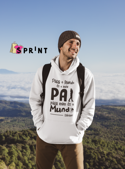 Homem jovem com hoodie branco e gorro castanho em paisagem montanhosa