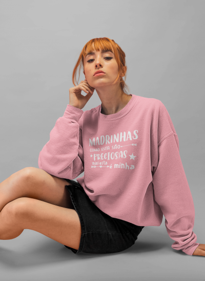 Mulher vestindo sweatshirt rosa com texto branco sentada no chão