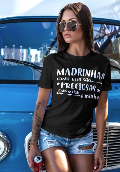 Mulher com t-shirt preta com texto branco e calções de ganga, junto a carrinha azul clássica