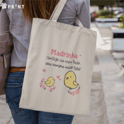 Mala de tecido estampada com texto e passarinhos, usada ao ombro numa rua