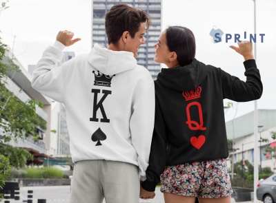 Casal vestido com hoodies estampados de cartas King e Queen ao ar livre