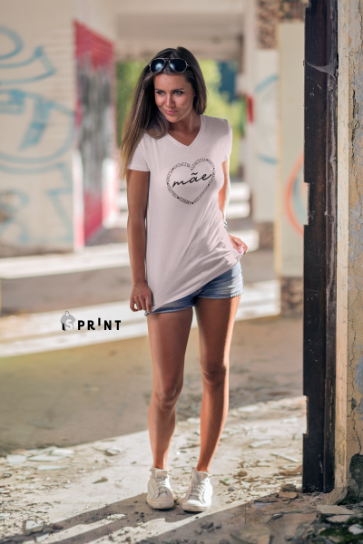 Mulher com t-shirt branca estampada e calções de ganga num espaço interior degradado
