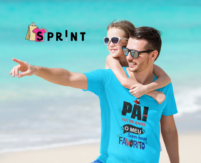 Homem com camisola azul clara com texto, rapariga ao colo, praia e mar ao fundo