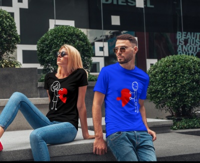 Dois jovens com t-shirts estampadas de peças de puzzle vermelhas sentados ao ar livre
