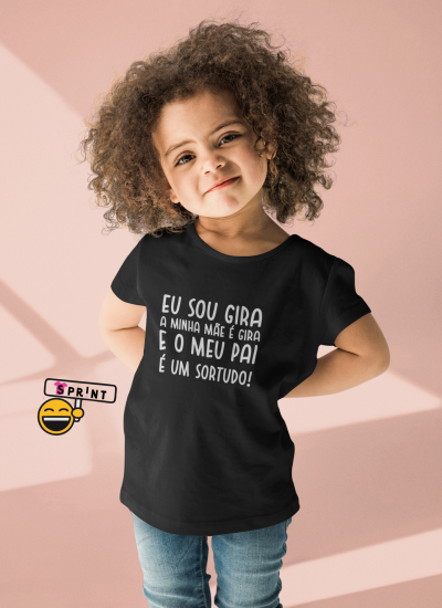 Camisola preta com texto em branco usada por criança em fundo rosa