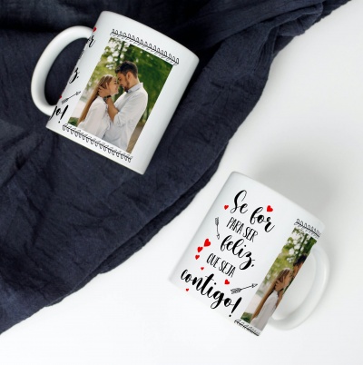 Duas canecas brancas com fotos de casal e texto em português sobre tecido azul escuro.