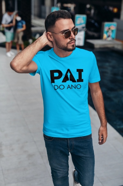 Homem com t-shirt azul turquesa com texto 'PAI DO ANO' e calças de ganga azuis