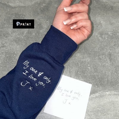 Manga de camisola azul escura com bordado e nota com texto em inglês