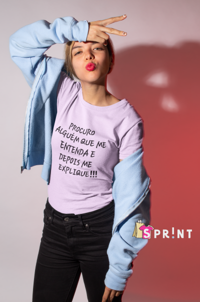 Camiseta lilás com texto preto 'PROCURA ALGUÉM QUE ME ENTENDA E DEPOIS ME EXPLIQUE!!!' com casaco azul claro e calças pretas em fundo rosa.