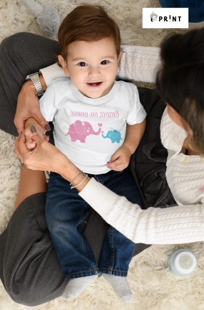 Bebé com camisola estampada de elefantes e texto sentado no colo da mãe