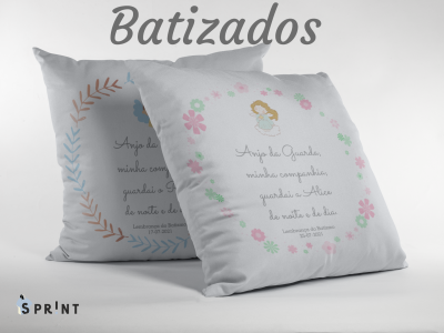 Duas almofadas brancas com molduras florais e texto alusivo a batizados