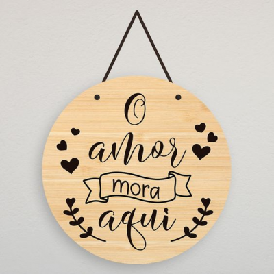 Placa redonda de madeira clara com texto em português e decoração em preto