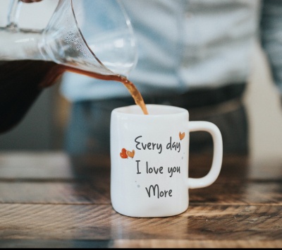 Caneca branca com texto e corações, café a ser servido nela