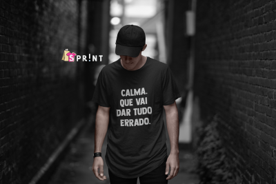 Homem com t-shirt preta e boné num beco entre paredes de tijolos