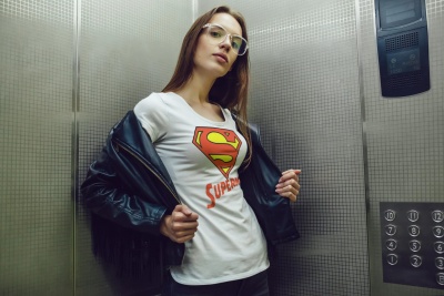 Mulher com t-shirt branca Super-Homem num elevador