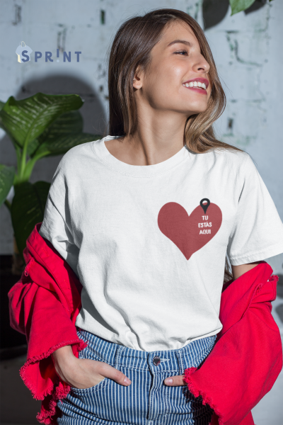 Camisola branca com coração vermelho e texto 'TU ESTÁS AQUI'