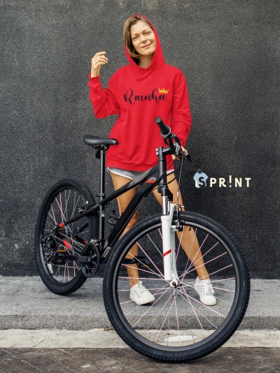 Mulher com capuz vermelho segurando bicicleta preta em fundo preto