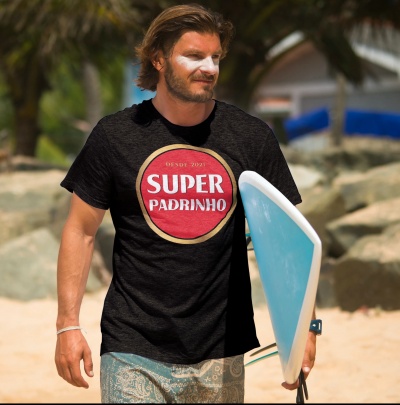 Homem com camiseta preta estampada 'SUPER PADRINHO' segurando prancha de surf azul claro na praia