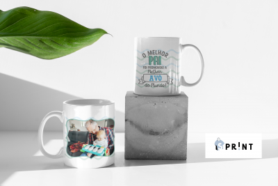 Duas canecas brancas, uma com foto de família e outra com texto em português, sobre fundo branco com bloco de cimento