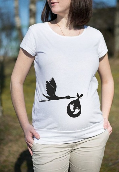 T-shirt branca para grávida com estampa preta de cegonha e pegadas de bebé