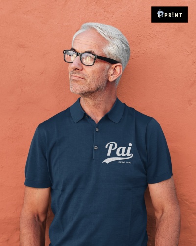 Homem a usar polo azul com texto Pai DESDE 1992 e óculos pretos, em frente a parede cor terracota, logotipo SPRINT