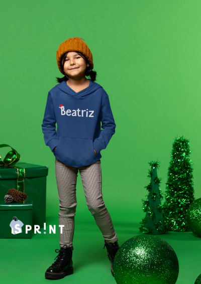 Criança com hoodie personalizado 'Beatriz' em cenário verde festivo