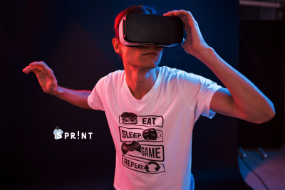 Pessoa com óculos de realidade virtual e camisa branca com texto e gráficos.