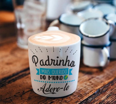 Caneca branca com texto sentimental sobre mesa de madeira
