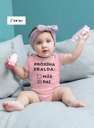 Bebé com body rosa e faixa de cabelo segurando blocos de construção