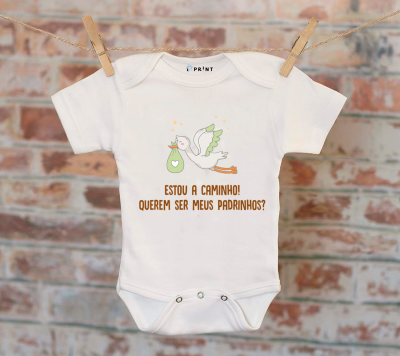 Body branco para bebé com cegonha e texto em português pendurado num estendal