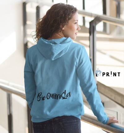 Mulher de costas a usar sweatshirt azul clara com texto preto 'Bio Química' na parte inferior das costas, em escadaria interior.