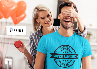 Casal com homem vestindo camiseta azul com texto e mulher segurando caixa em forma de coração