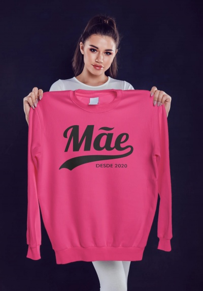 Sweatshirt rosa com texto 'Mãe DESDE 2020' segurada por mulher