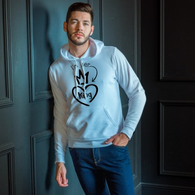 Homem com hoodie cinza claro com texto e desenho preto encostado na parede