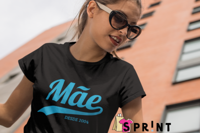 Camiseta preta com texto azul 'Mãe DESDE 2004' usada por mulher com óculos de sol