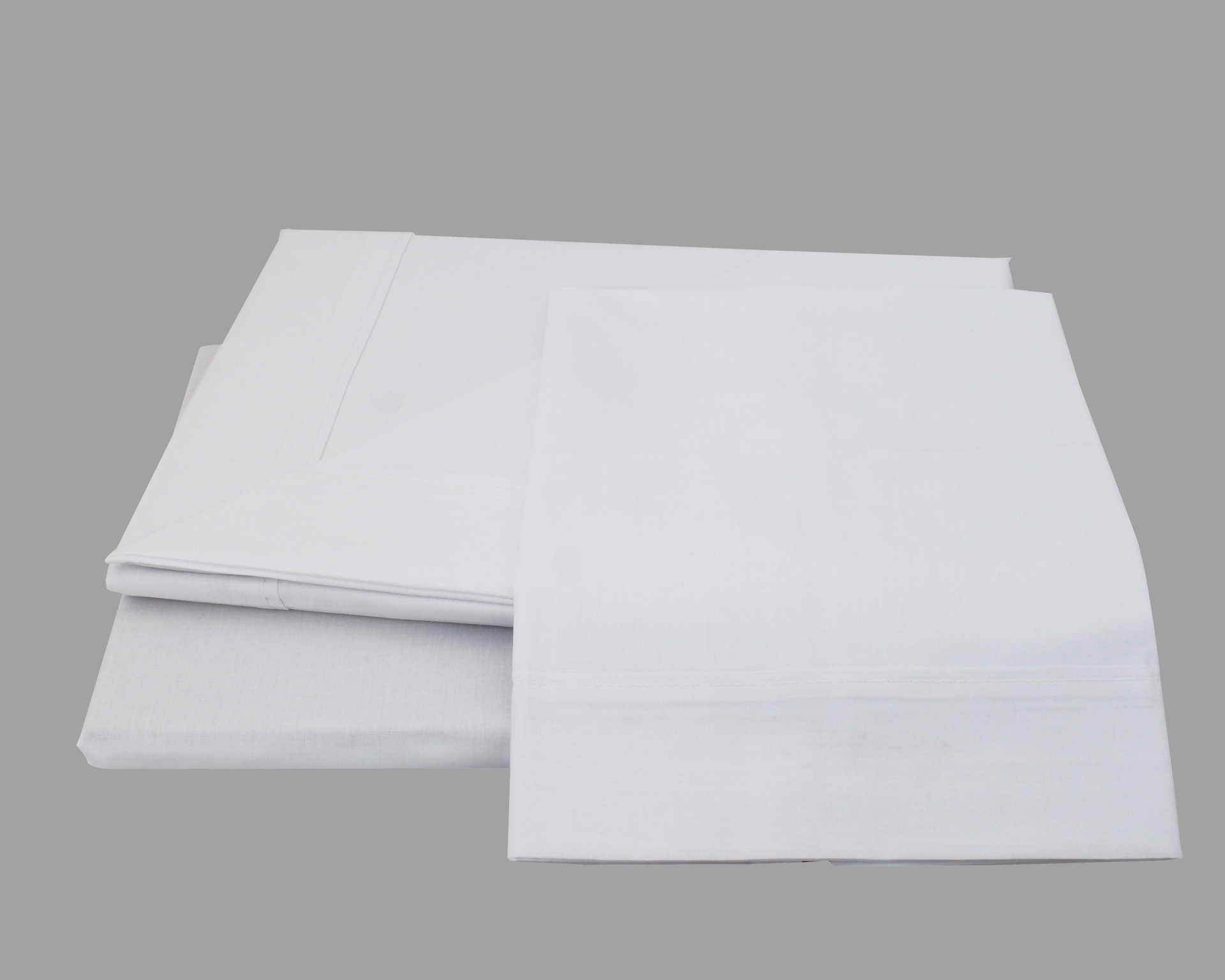 Conjunto de roupa de cama branca de algodão sobre superfície cinza