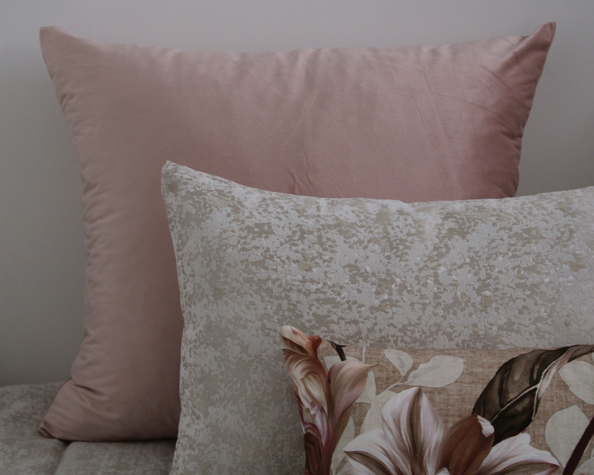 Três almofadas decorativas com padrões e cores diferentes