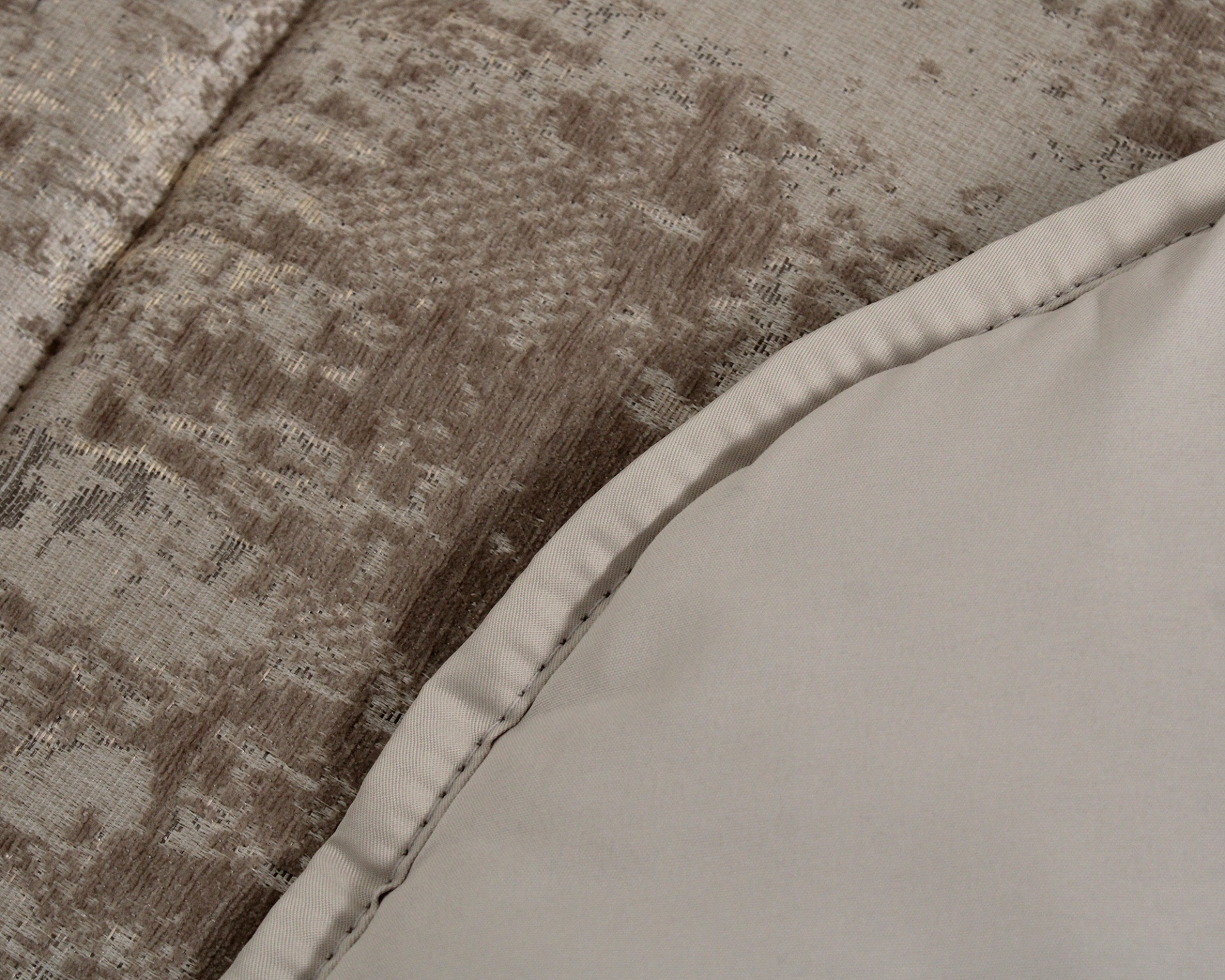Detalhe de tecidos texturizados e lisos em tons de bege e castanho